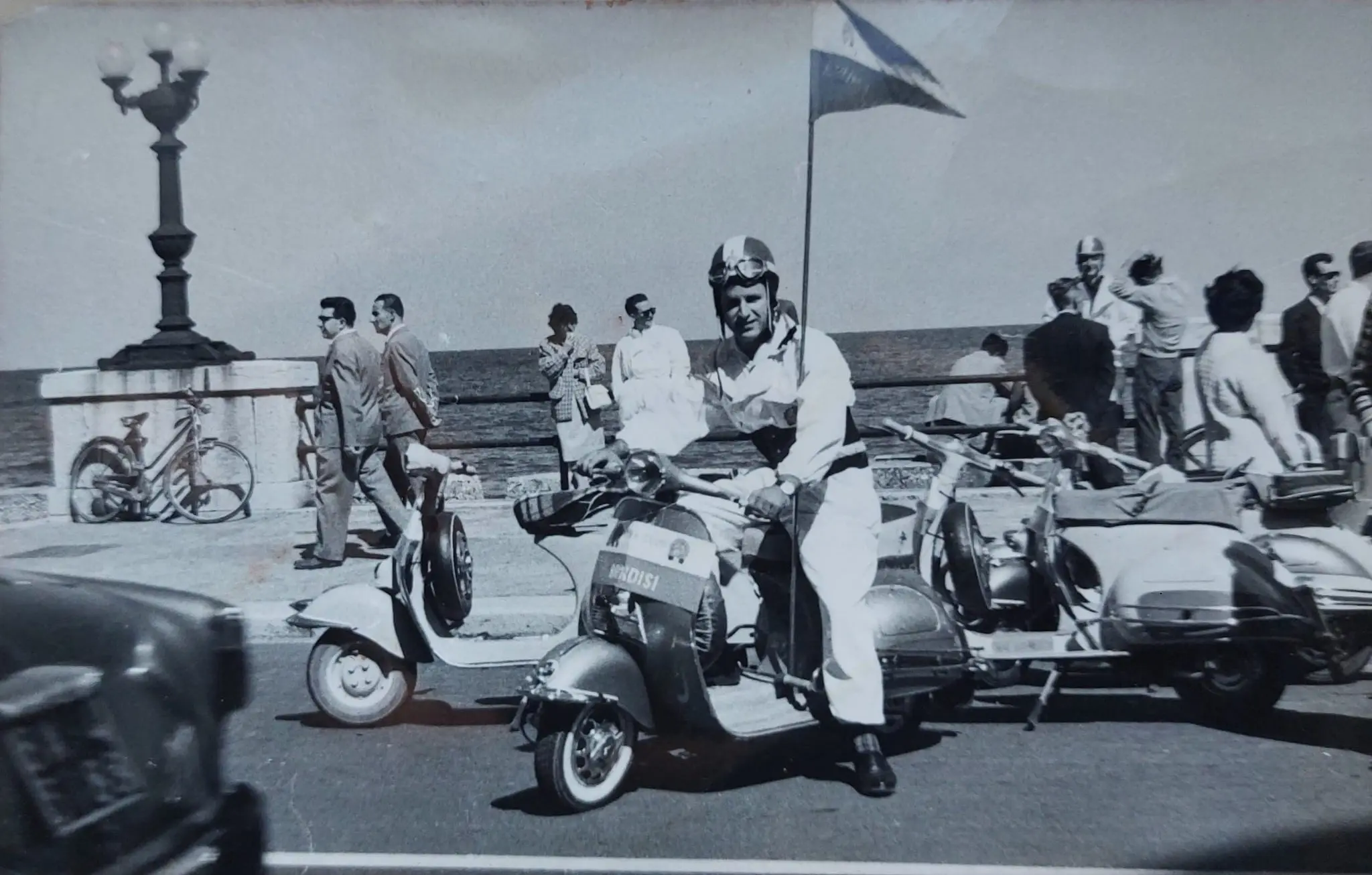 Vespa Club Brindisi anni Cinquanta porta bandiera in sella alla Vespa con il vessillo