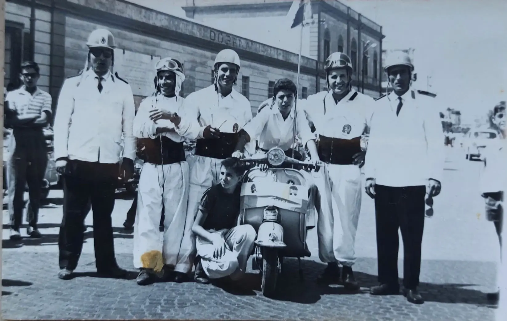 Soci del Vespa Club Brindisi intorno a una Vespa con bandierina anni Sessanta